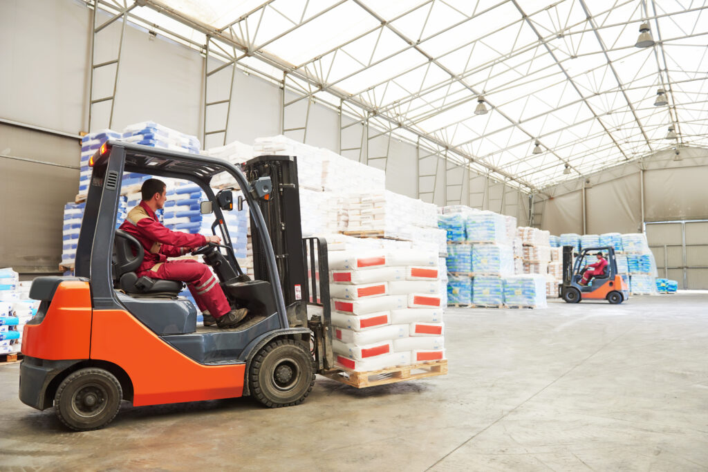 Man using industrial forklifts in warehouse environment 